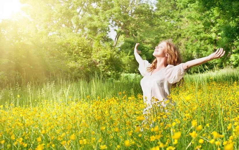 blissful woman with arms stretched out to the side